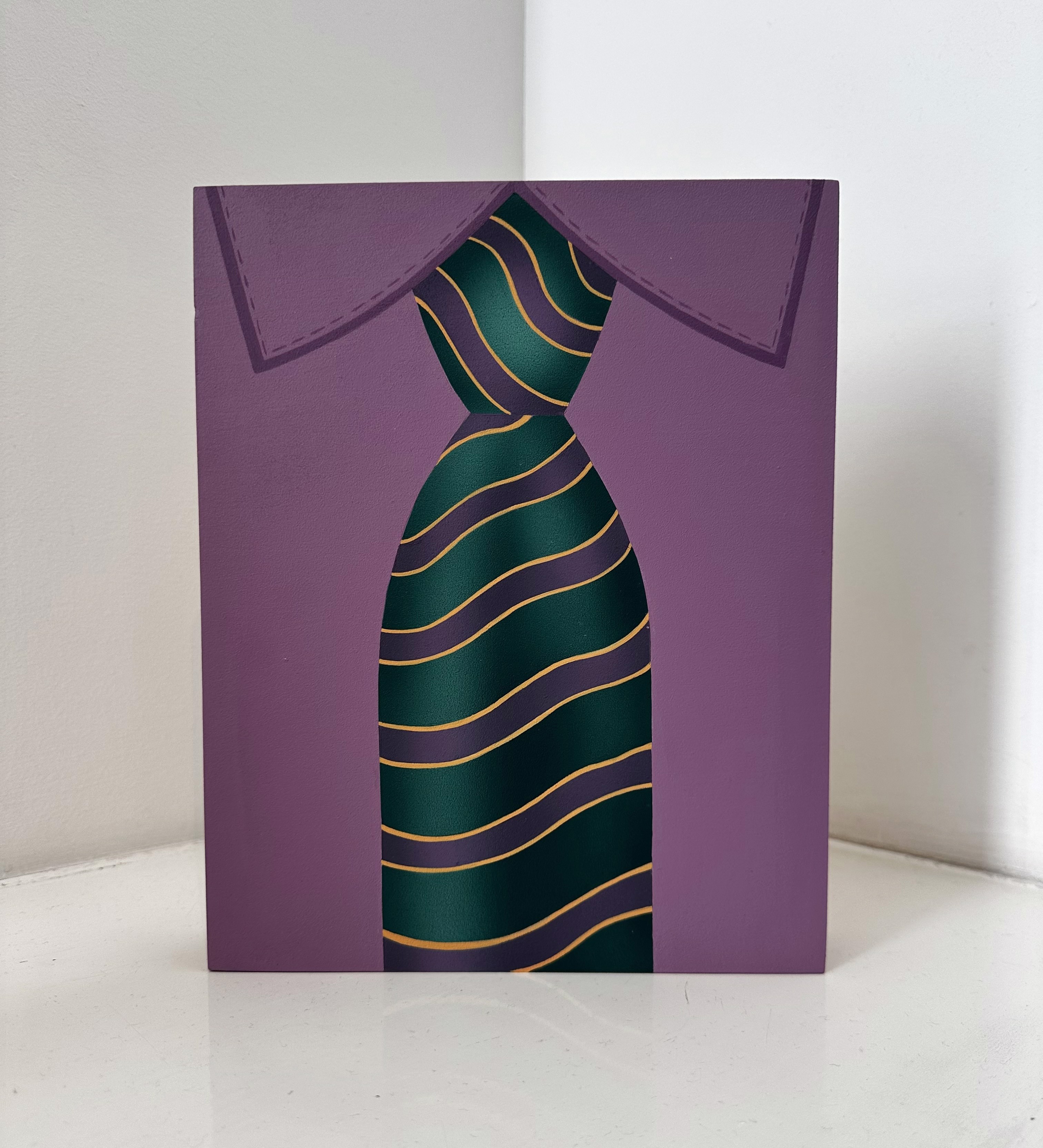 A purple card with a green and yellow striped tie.