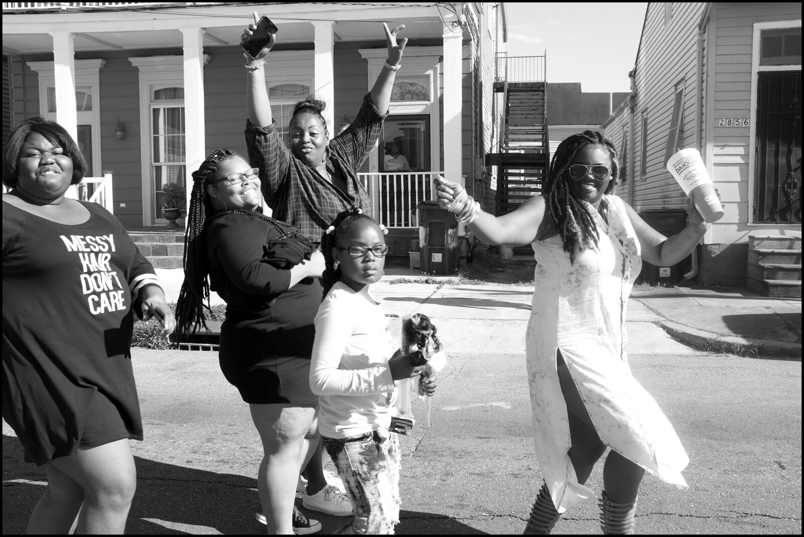 A group of women standing next to each other on a street.