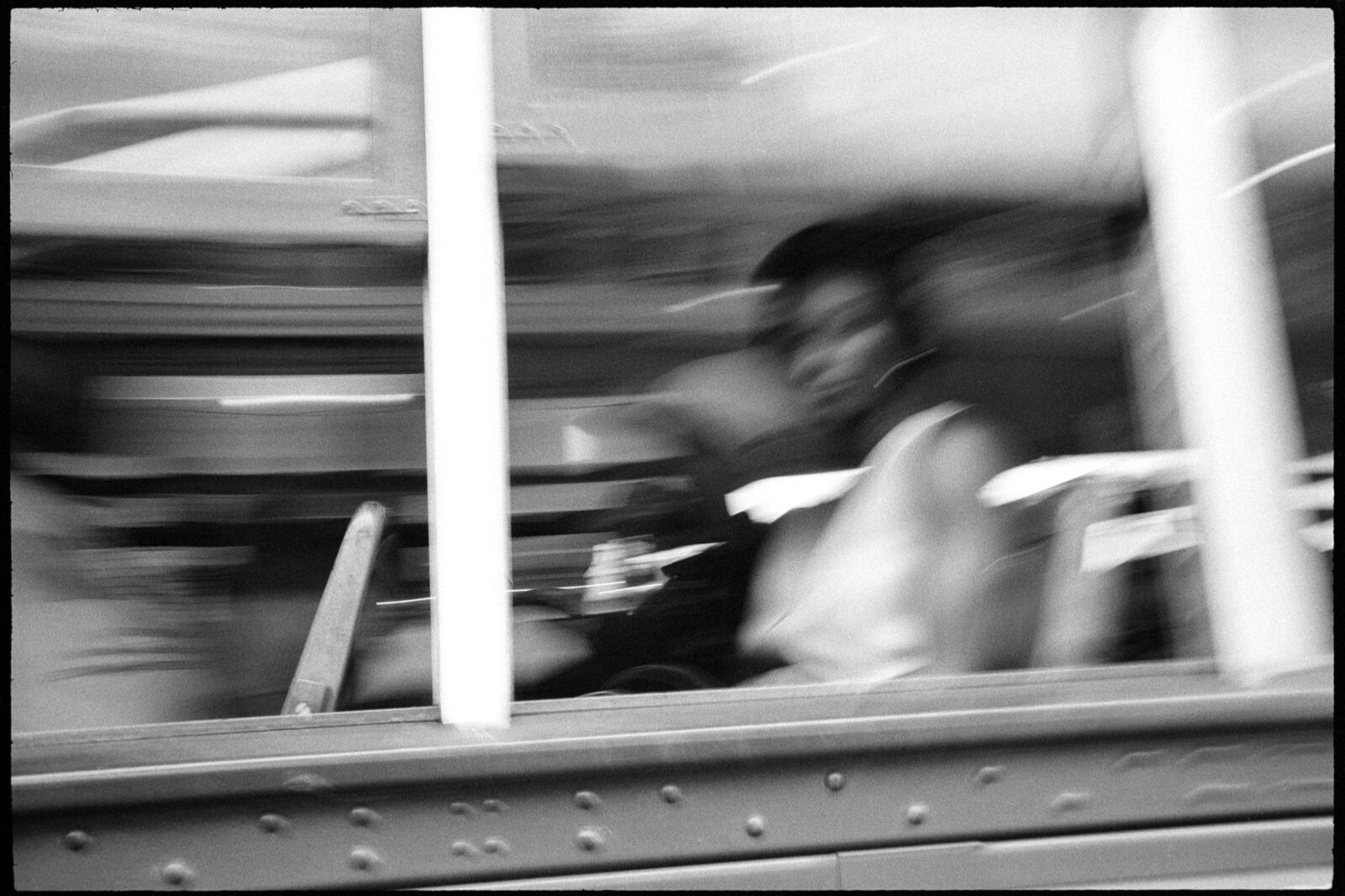 A black and white photo of people riding a bus.