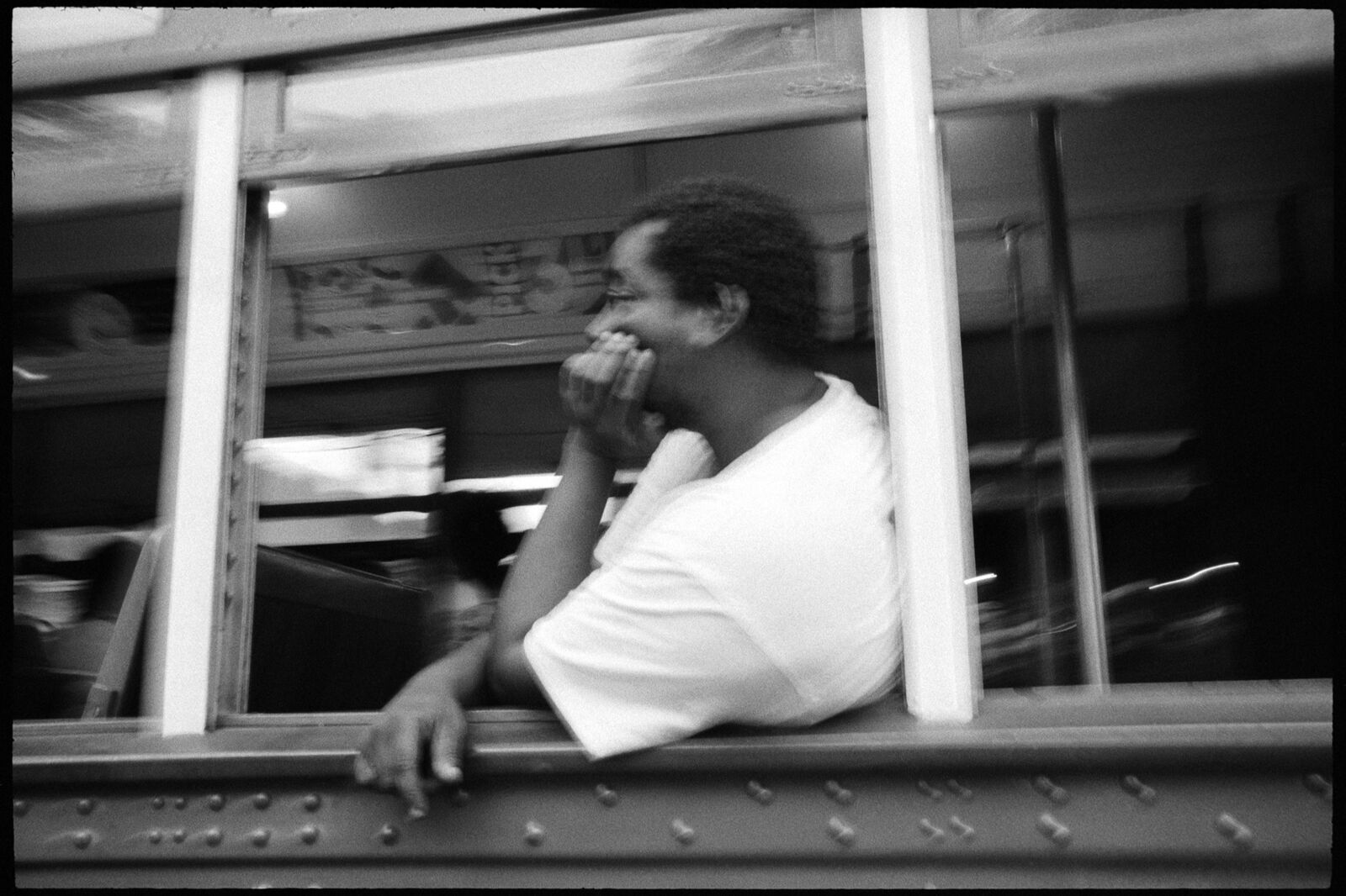 A man sitting on a bus talking on a cell phone.