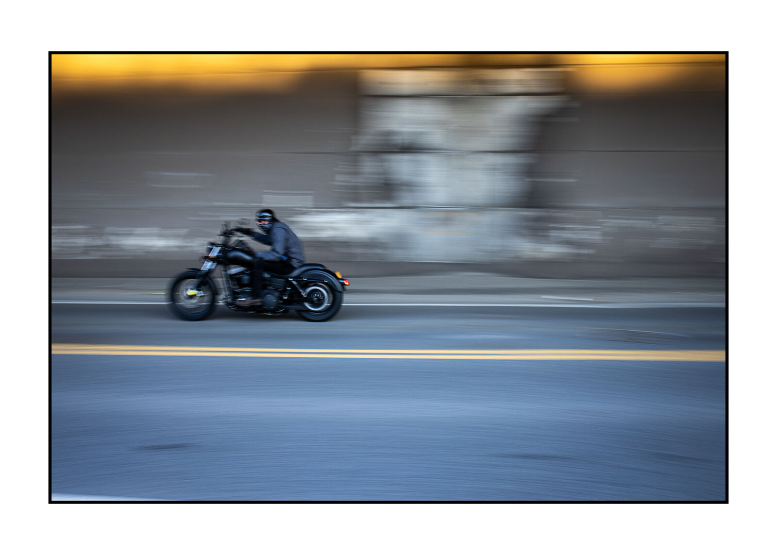 A man riding a motorcycle down a street at night.