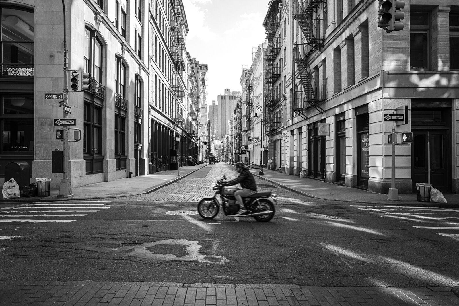 A man riding a motorcycle down a city street.