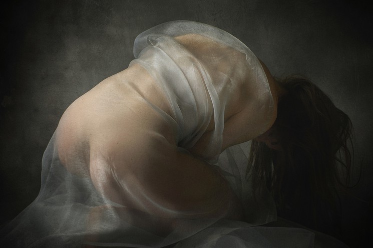 A woman in a white dress with a veil over her head.