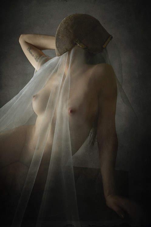 A nude woman with a veil covering her face.