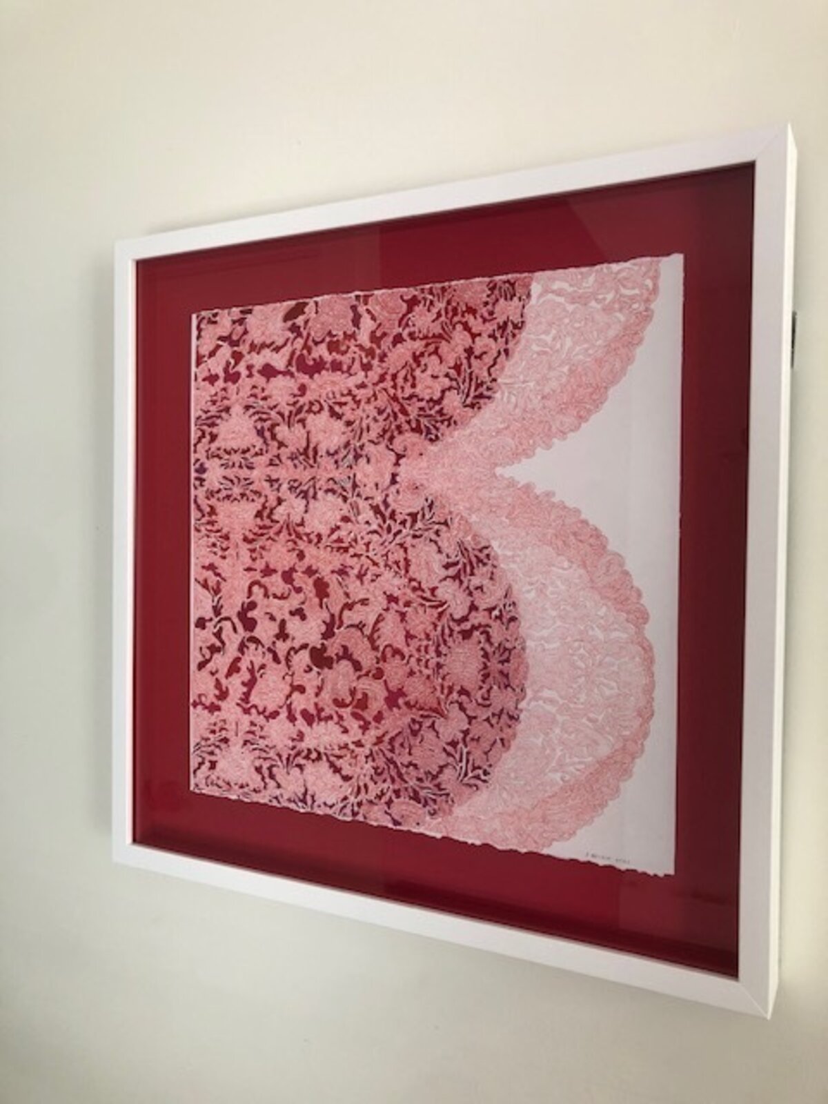 A dense, abstract composition of swirling red and pink lines on a white background.