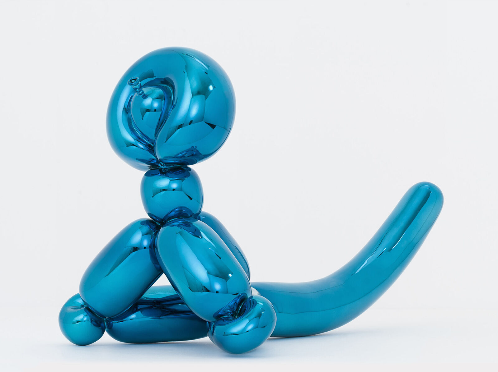 A blue balloon sculpture of a dog sitting on its hind legs.