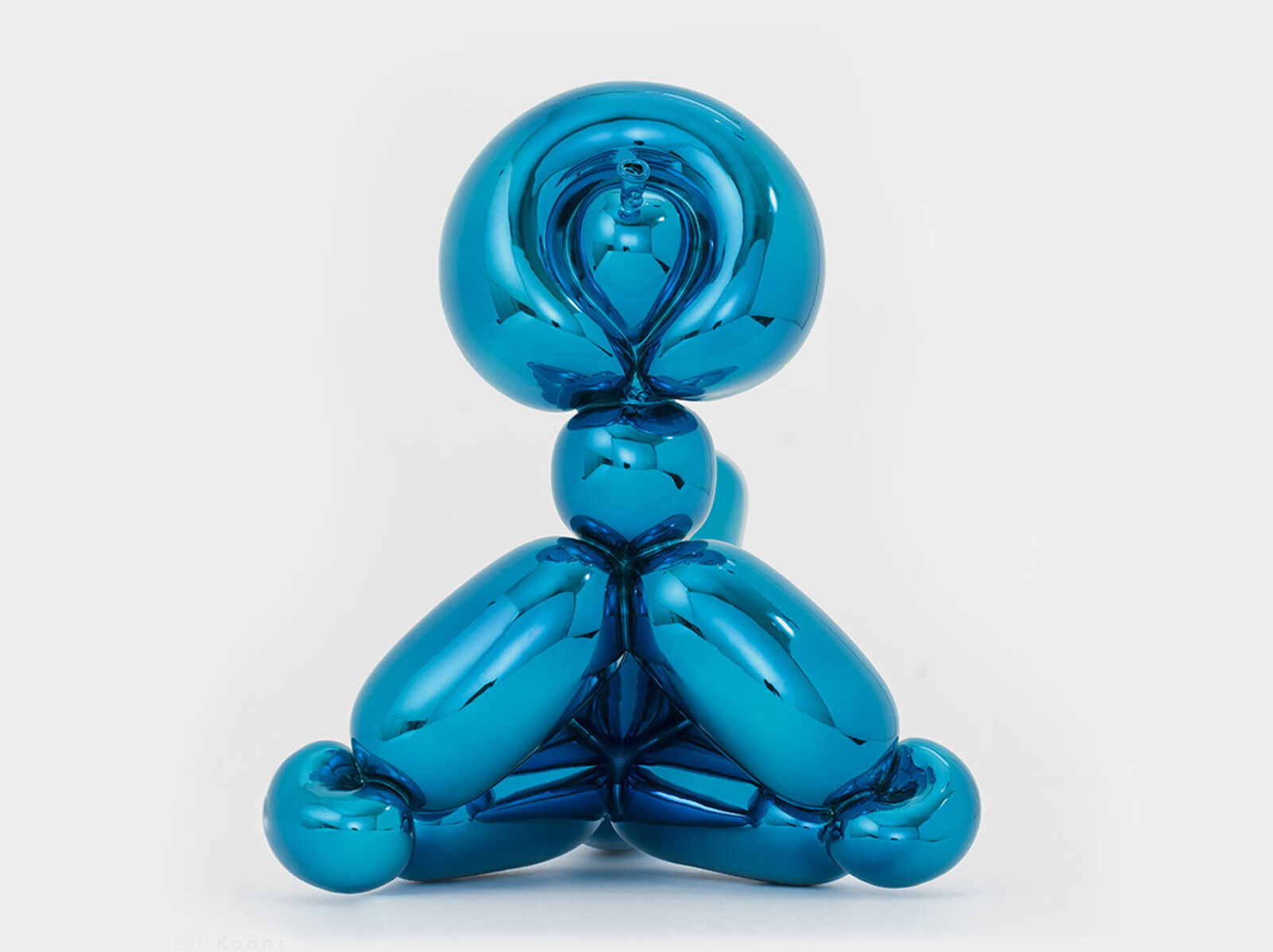 A blue balloon sculpture of a dog sitting on its hind legs.