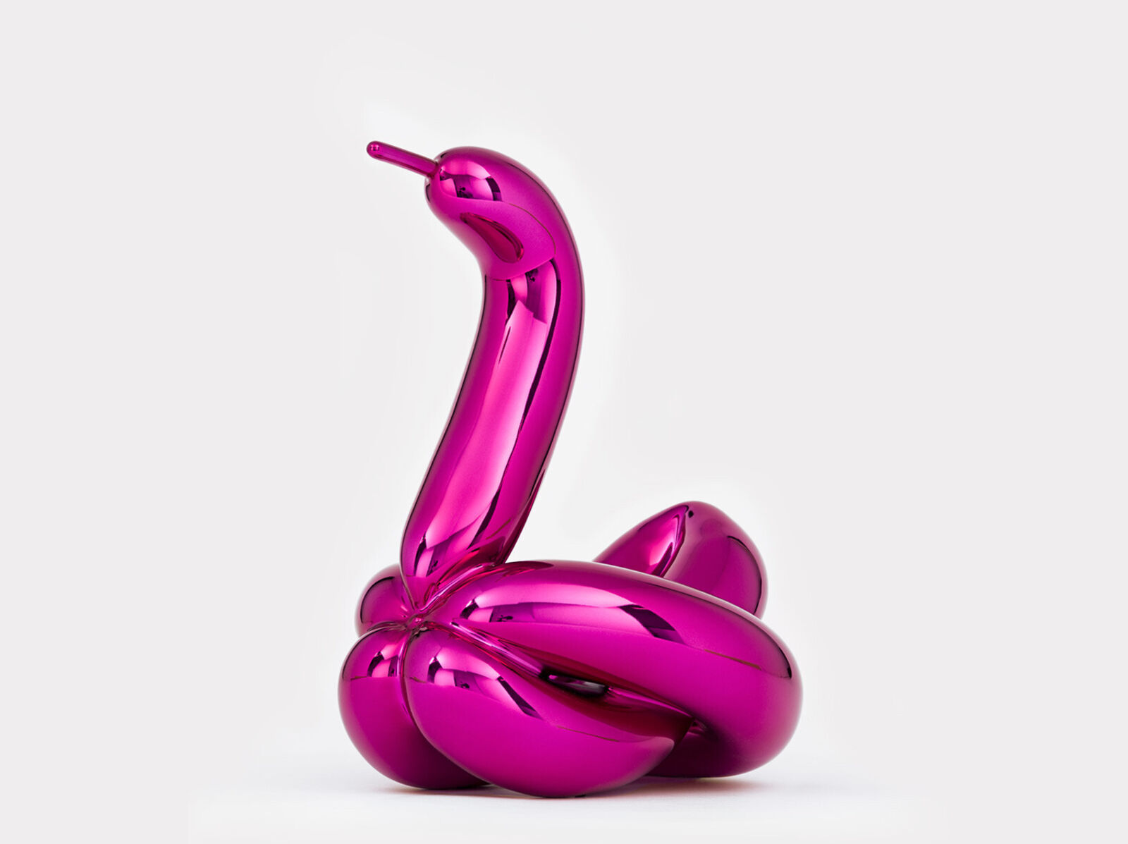A pink sculpture of a snake on a white background.