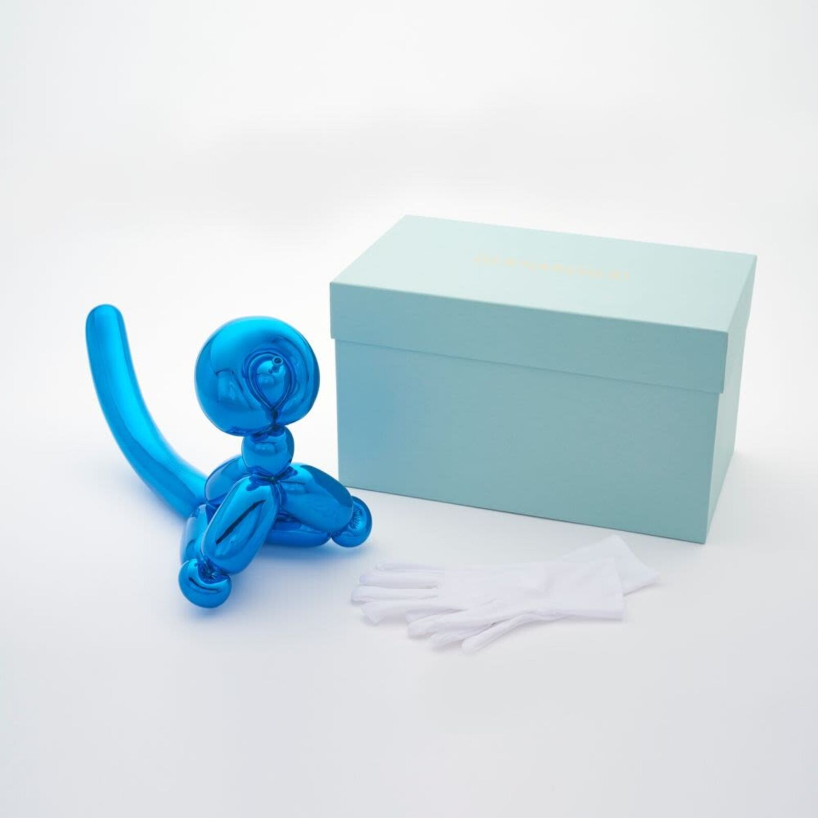 A blue balloon dog sitting on top of a white surface.