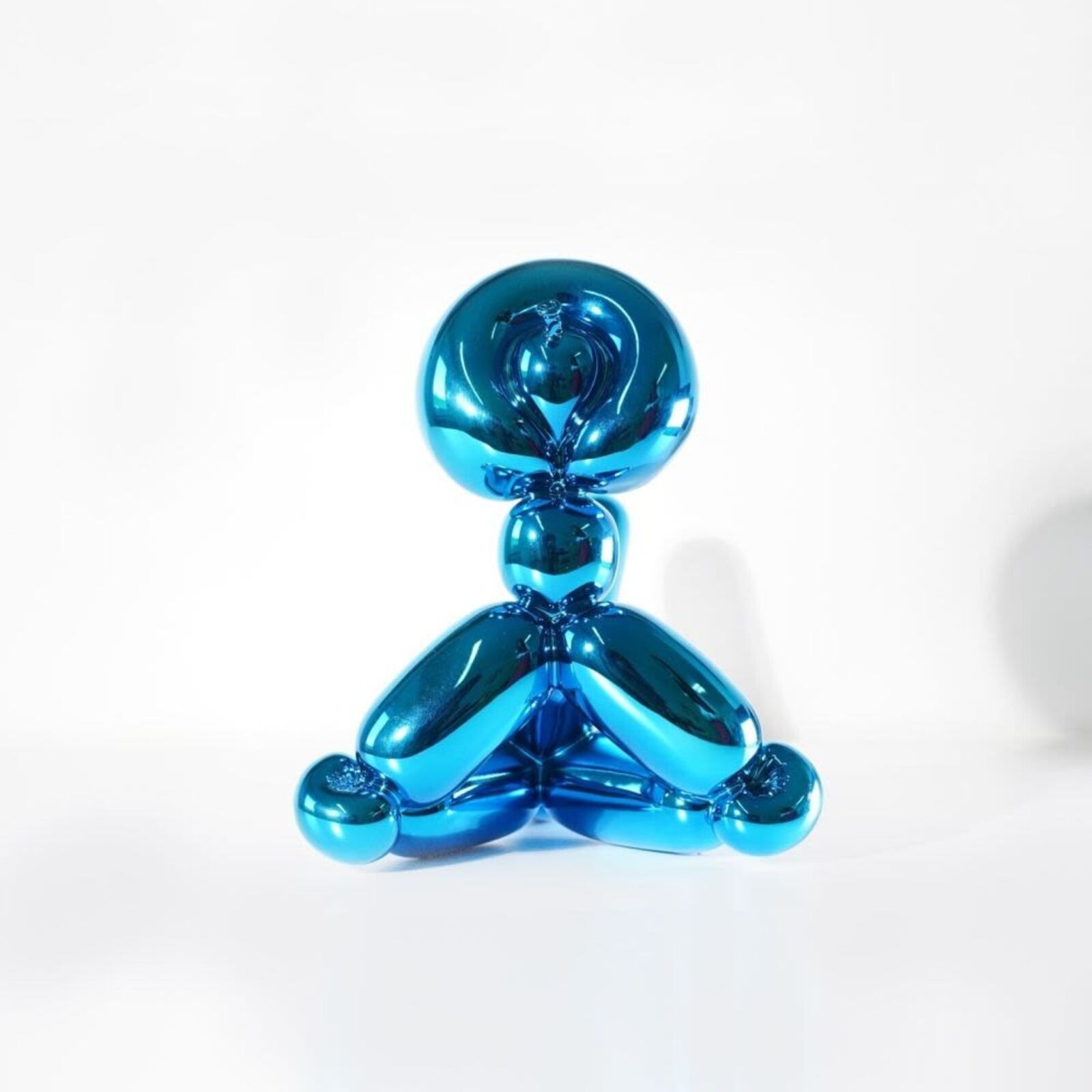 A blue balloon dog sitting on top of a white surface.