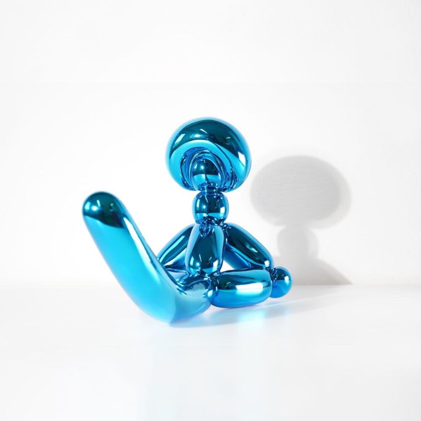A blue balloon dog sitting on top of a white surface.