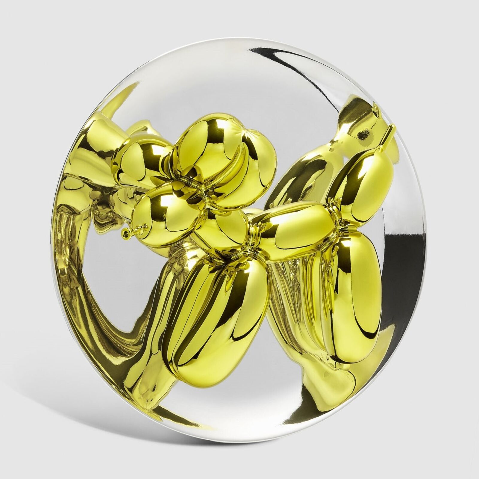 A trio of glossy, metallic balloon-dog sculptures displayed on clear stands against a neutral background.
