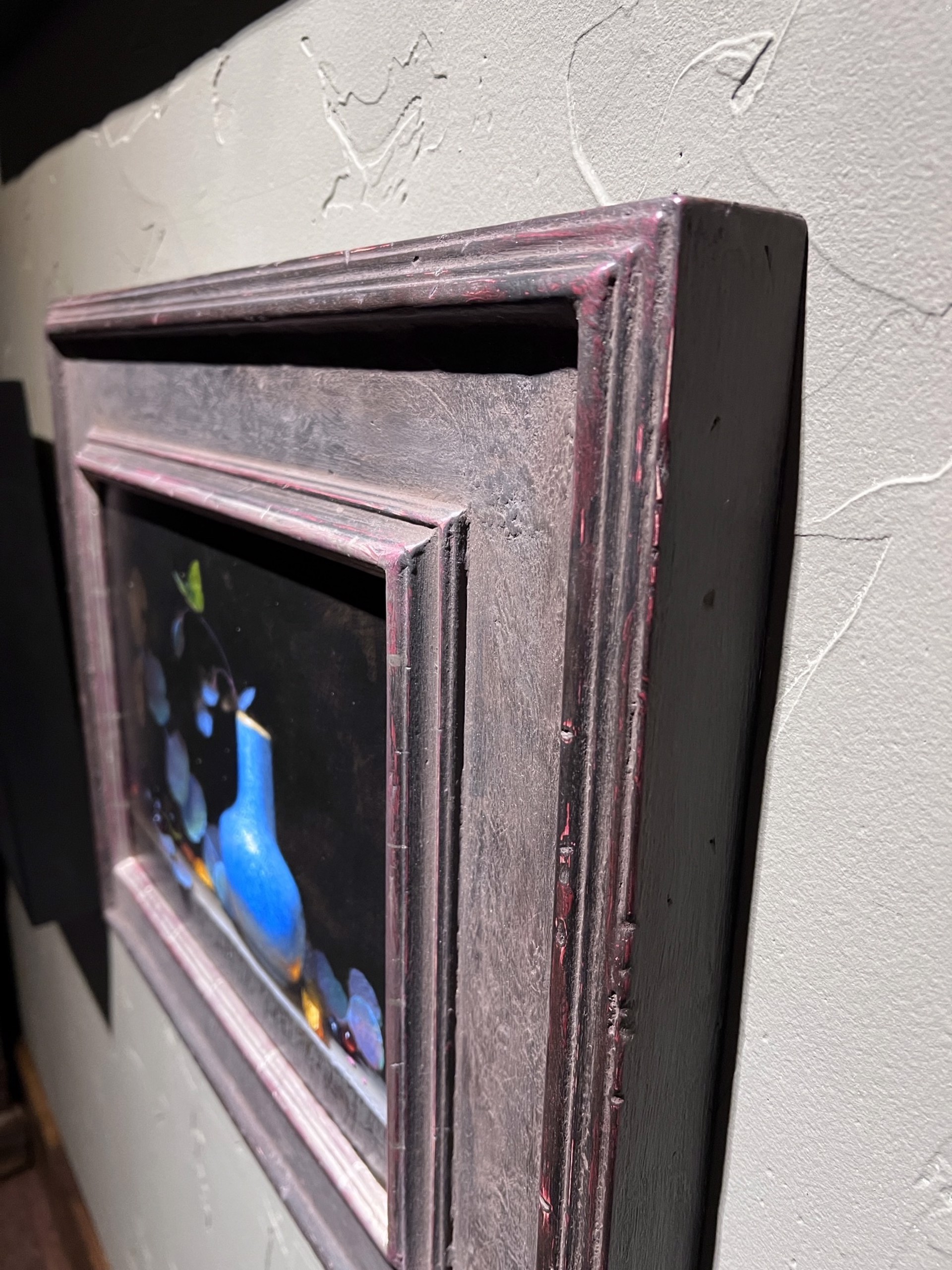 A painting of a blue vase sitting on a ledge.