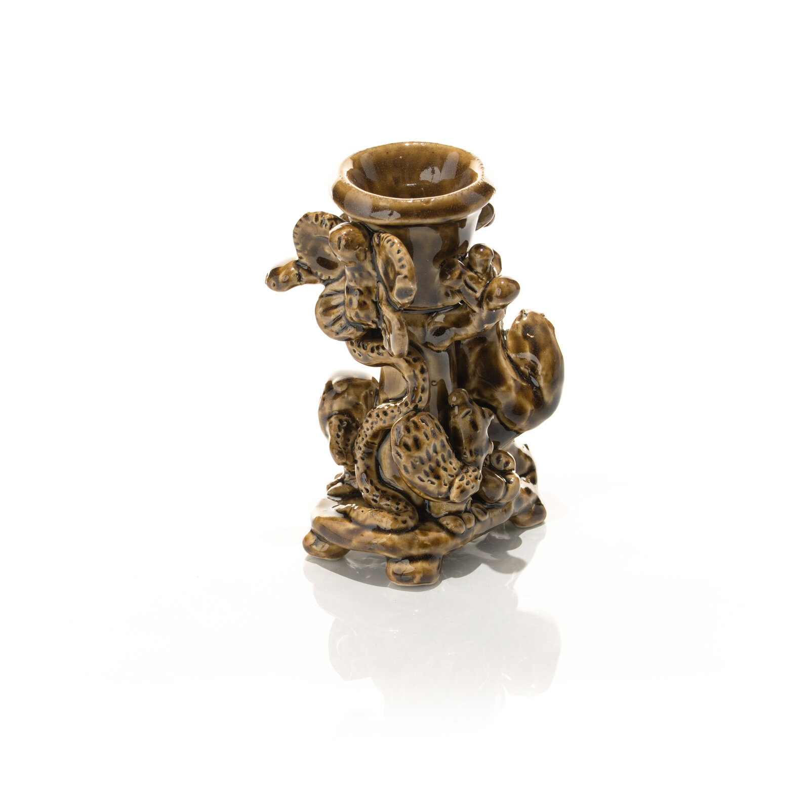 A glossy brown ceramic candlestick featuring a textured, organic design with animal-like figures and floral elements.