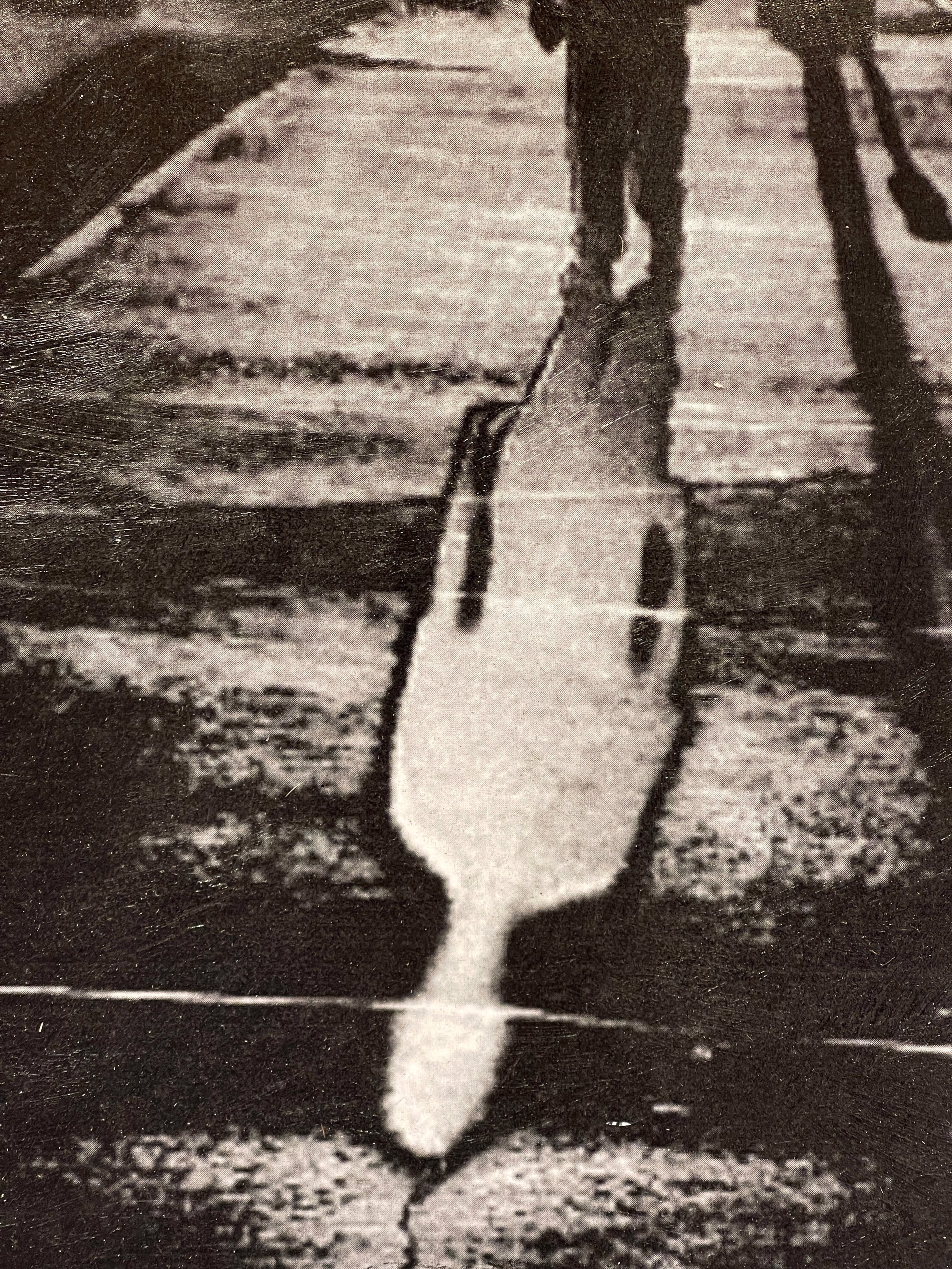 A black and white photo of a person walking down a street.