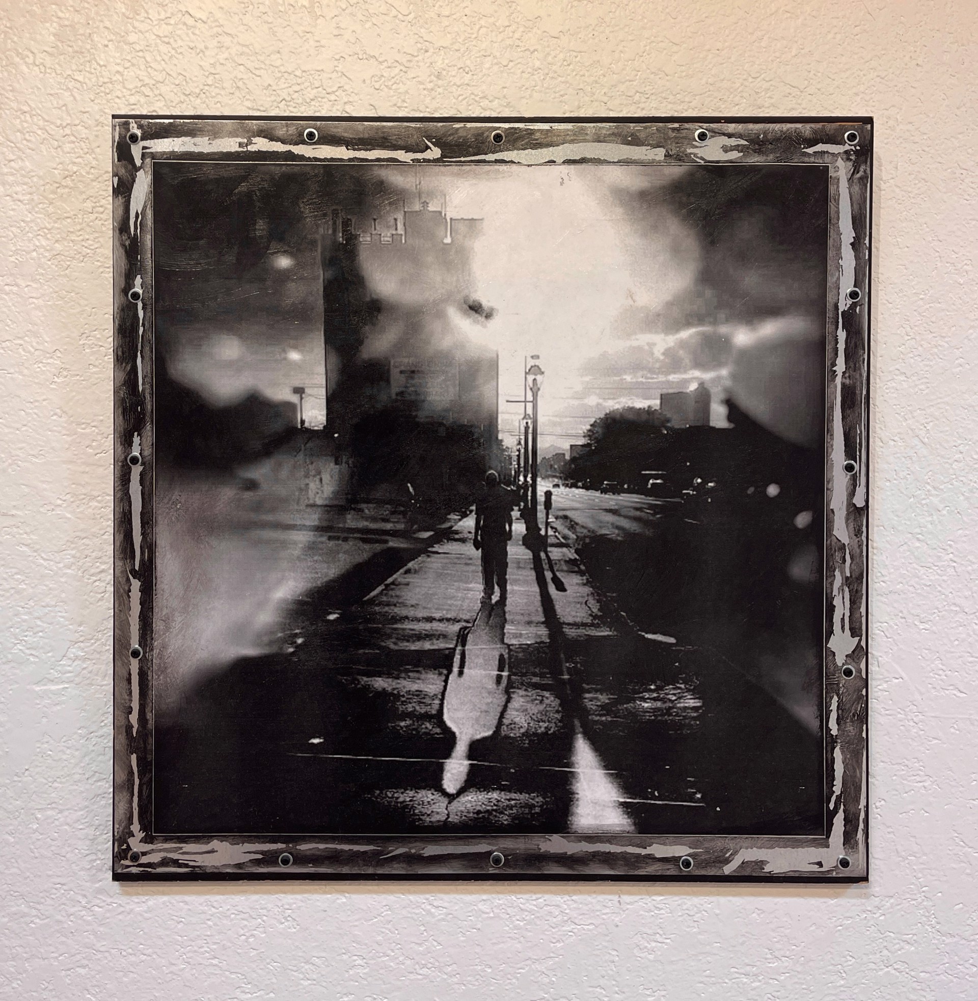 A black and white photo of a person walking down a street.