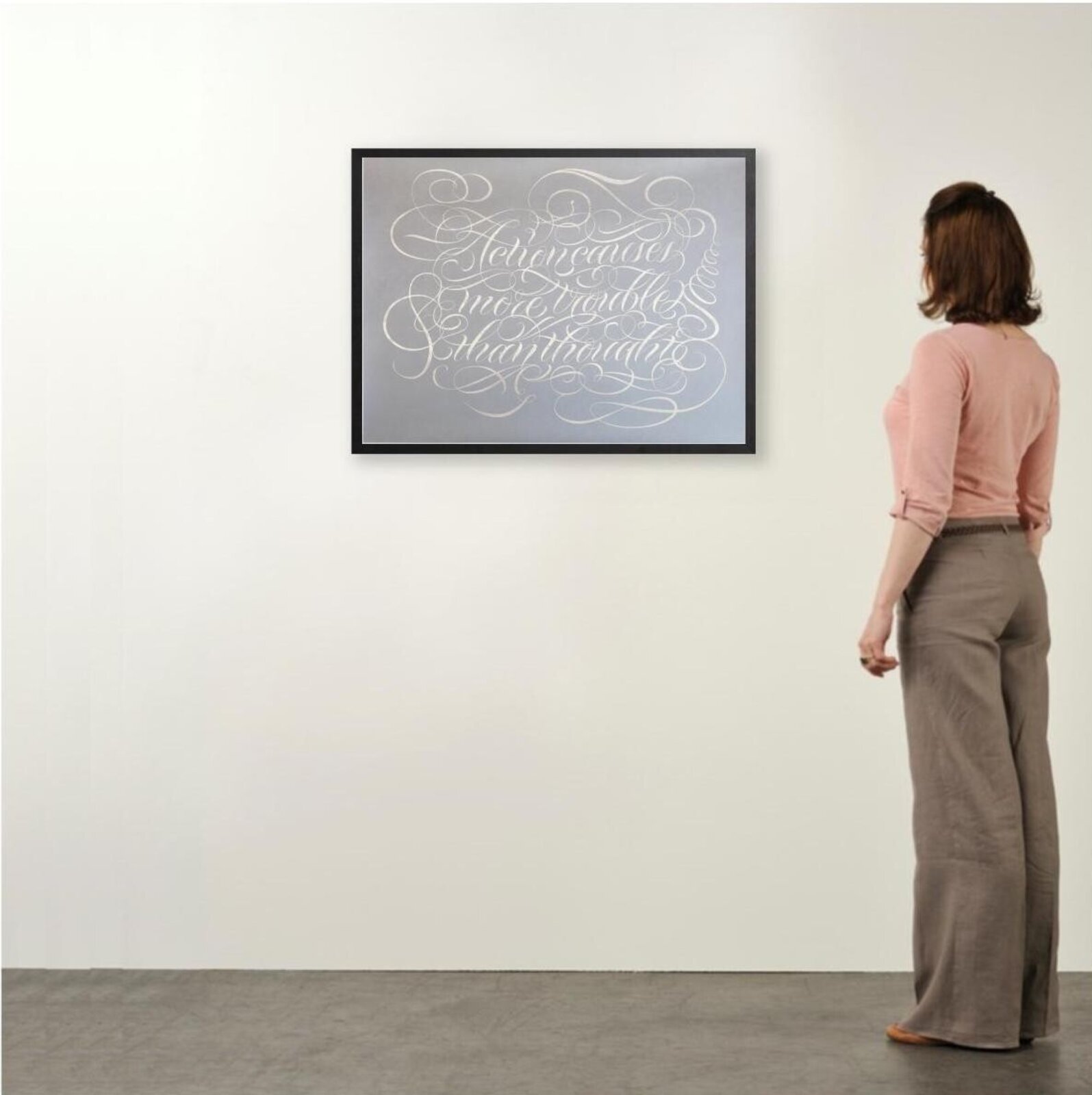 A silver metallic print of ornate calligraphy on a matte grey background.