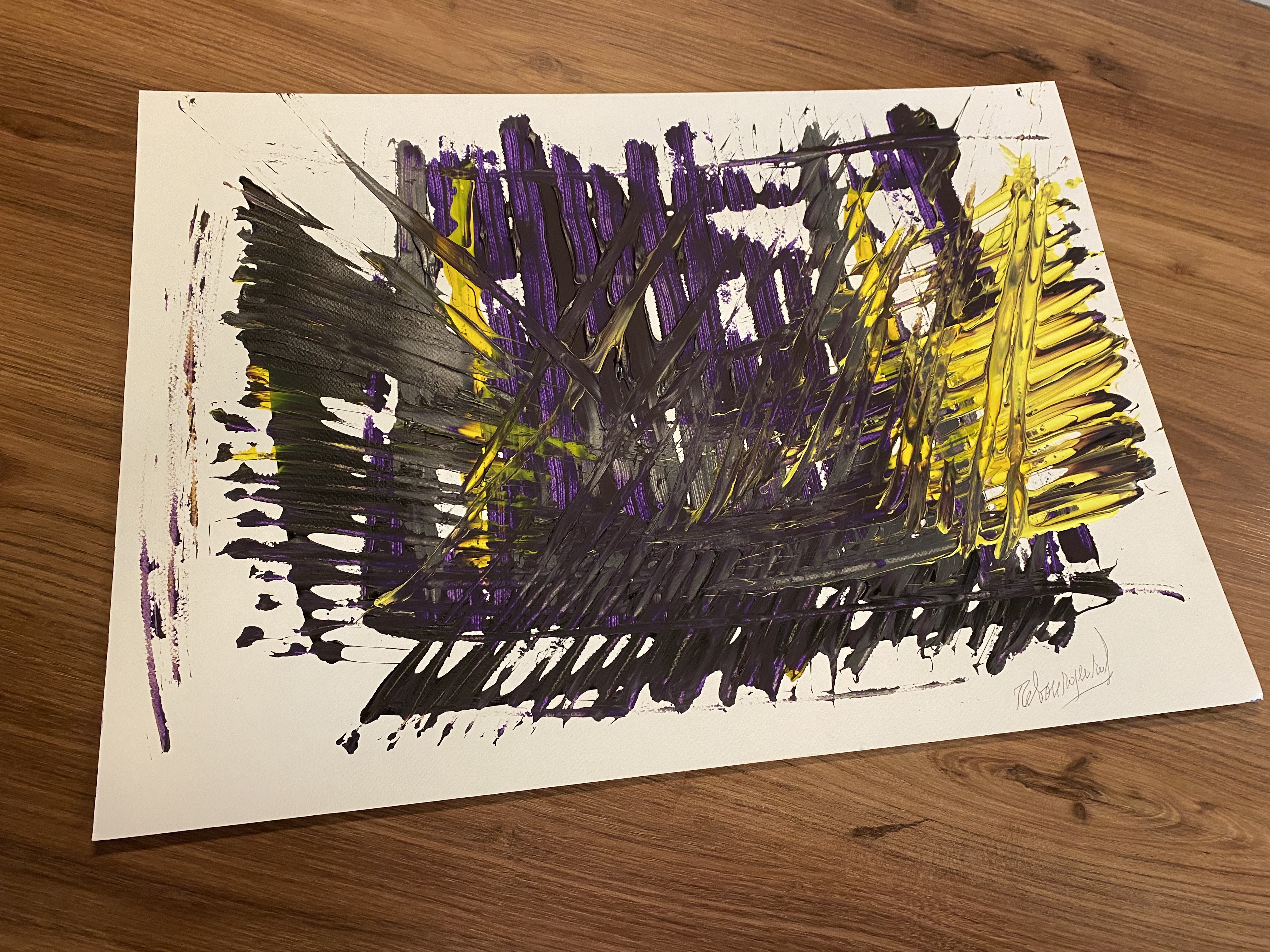 A painting on a wooden table with purple and yellow paint.