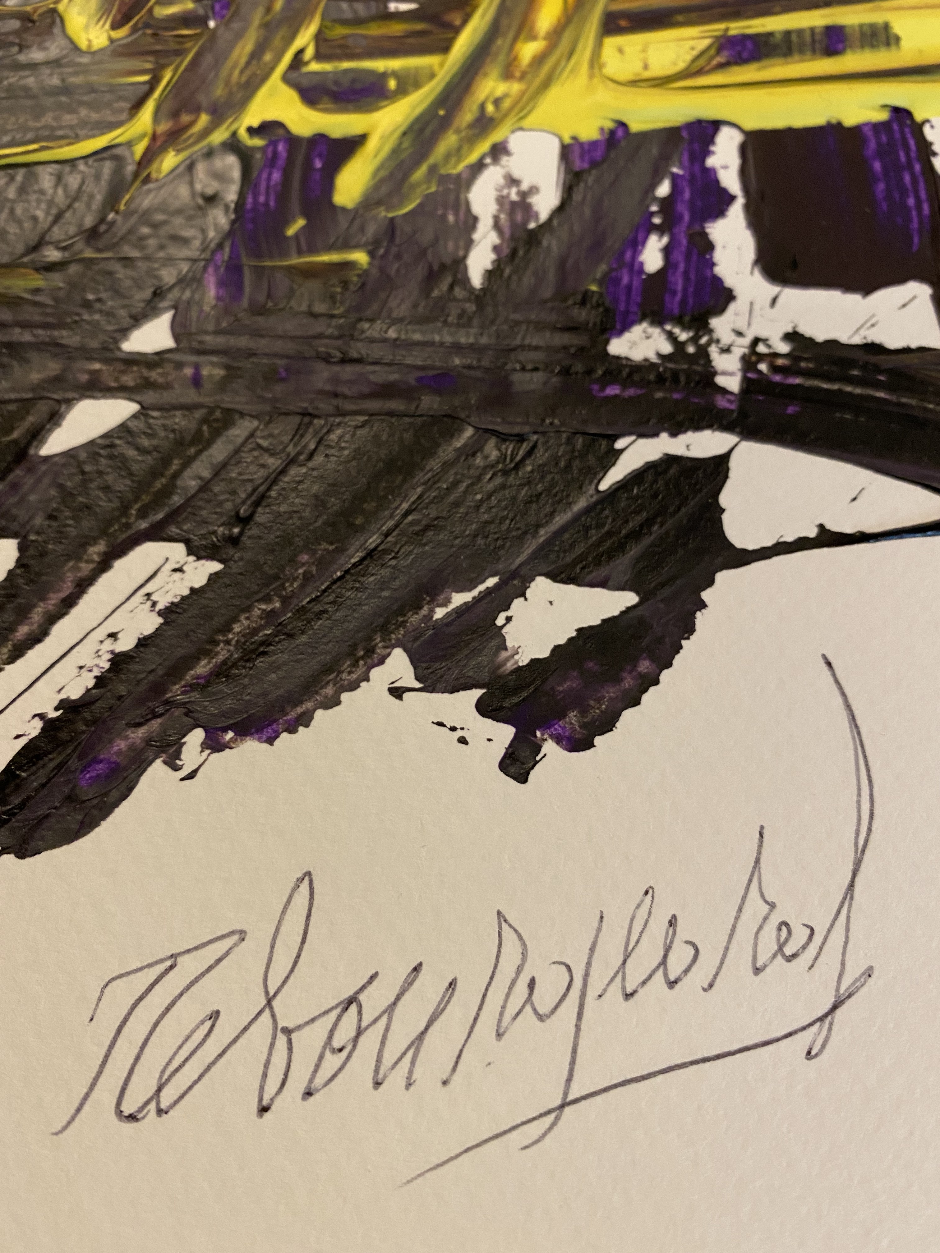 A painting on a wooden table with purple and yellow paint.