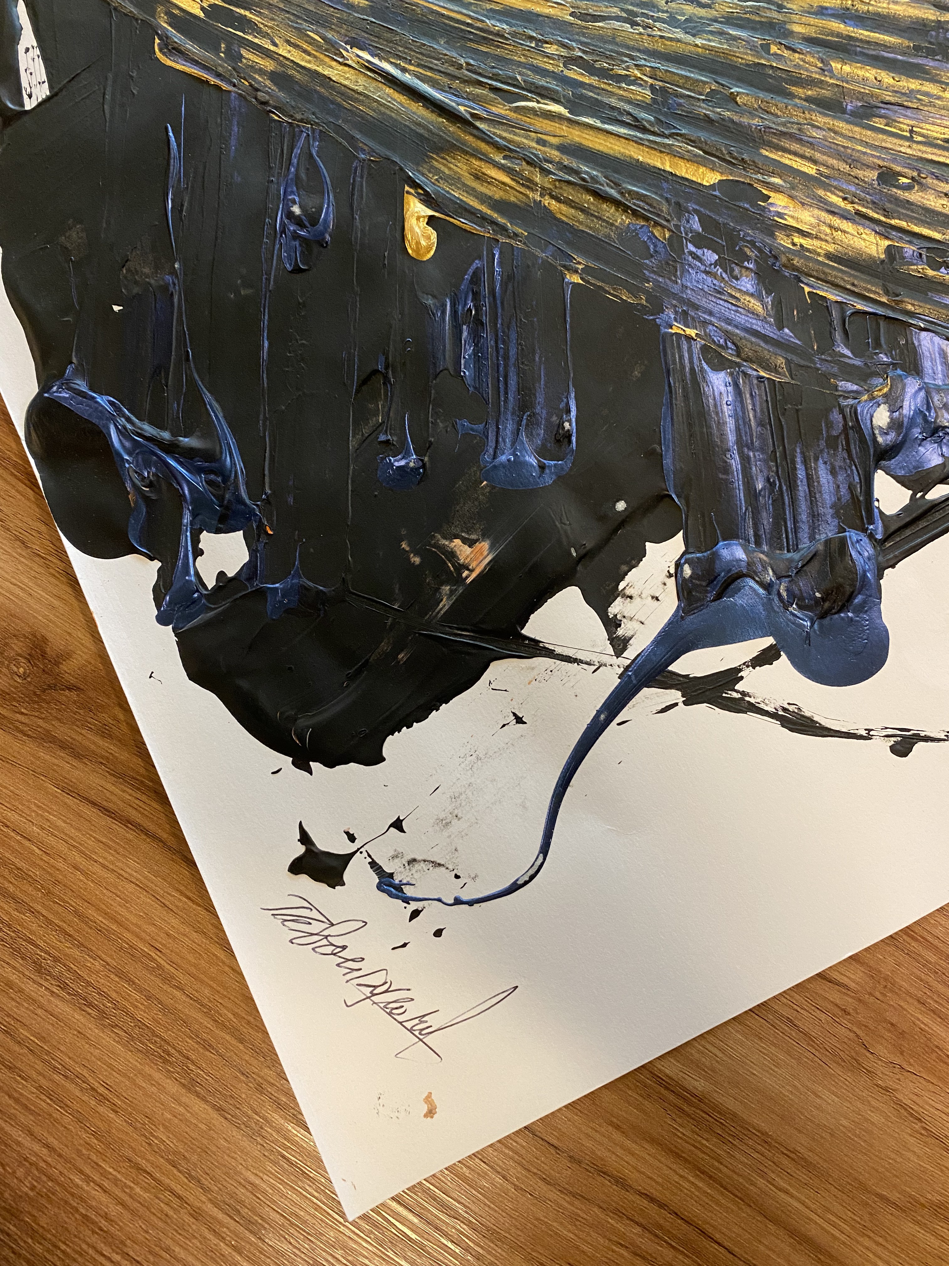 A dynamic abstract expressionist piece featuring bold, layered brushstrokes in black, blue, and gold on a white canvas.