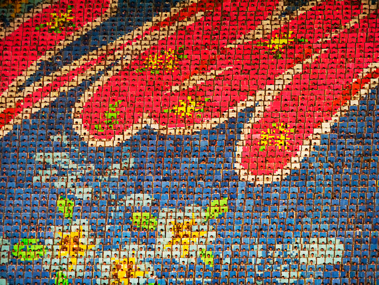 A mosaic of a large group of people on a wall.