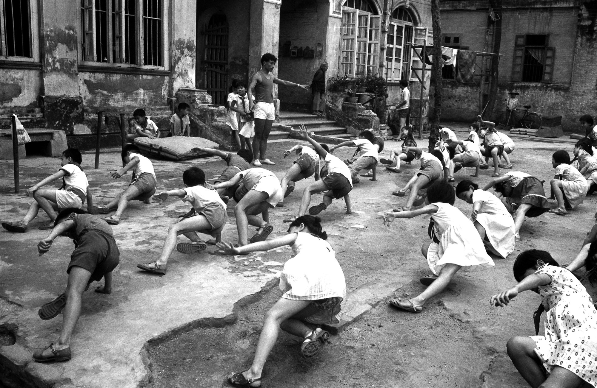 A group of children playing a game of tug of war on the street.