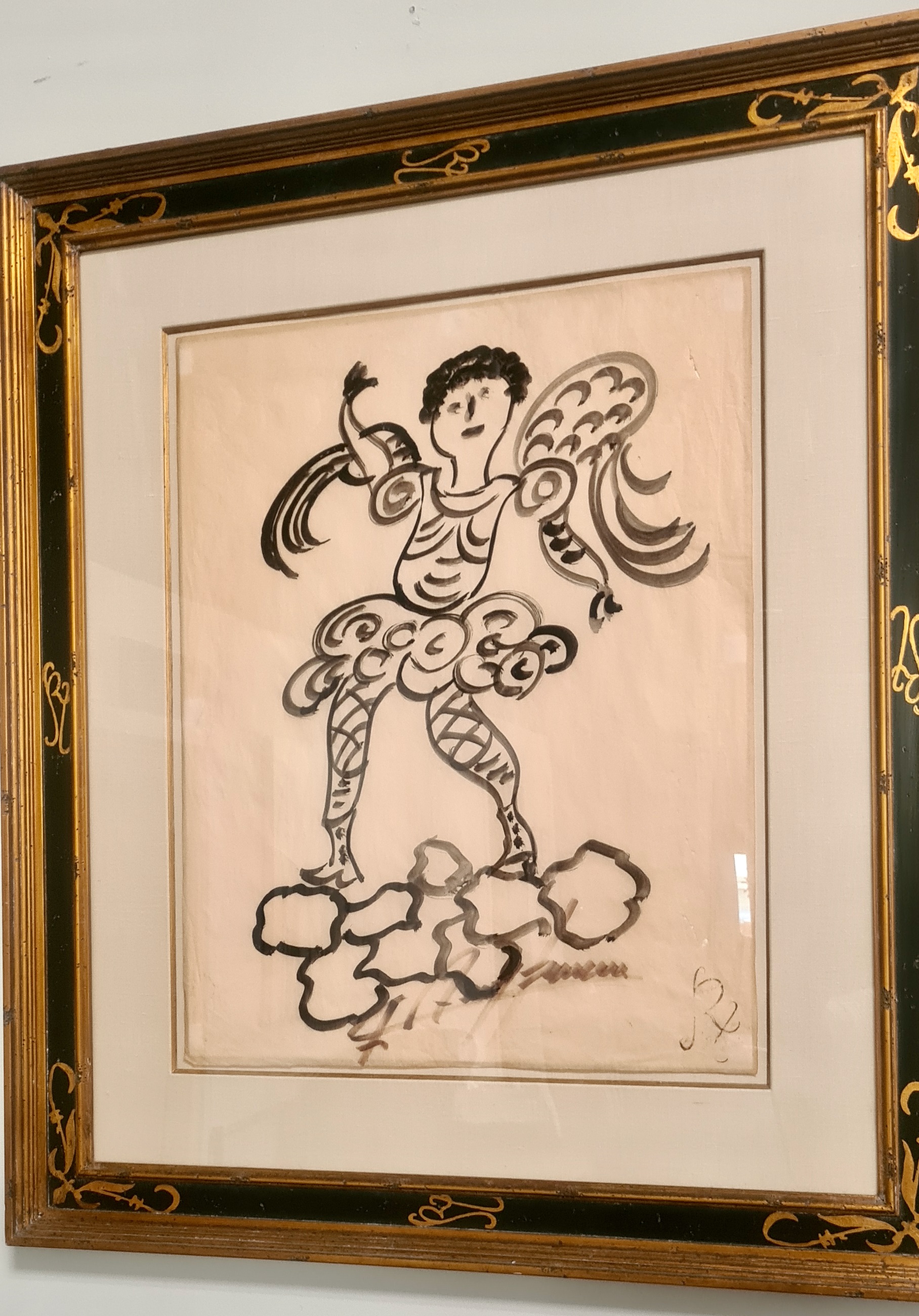 A framed drawing of an angel on a cloud.