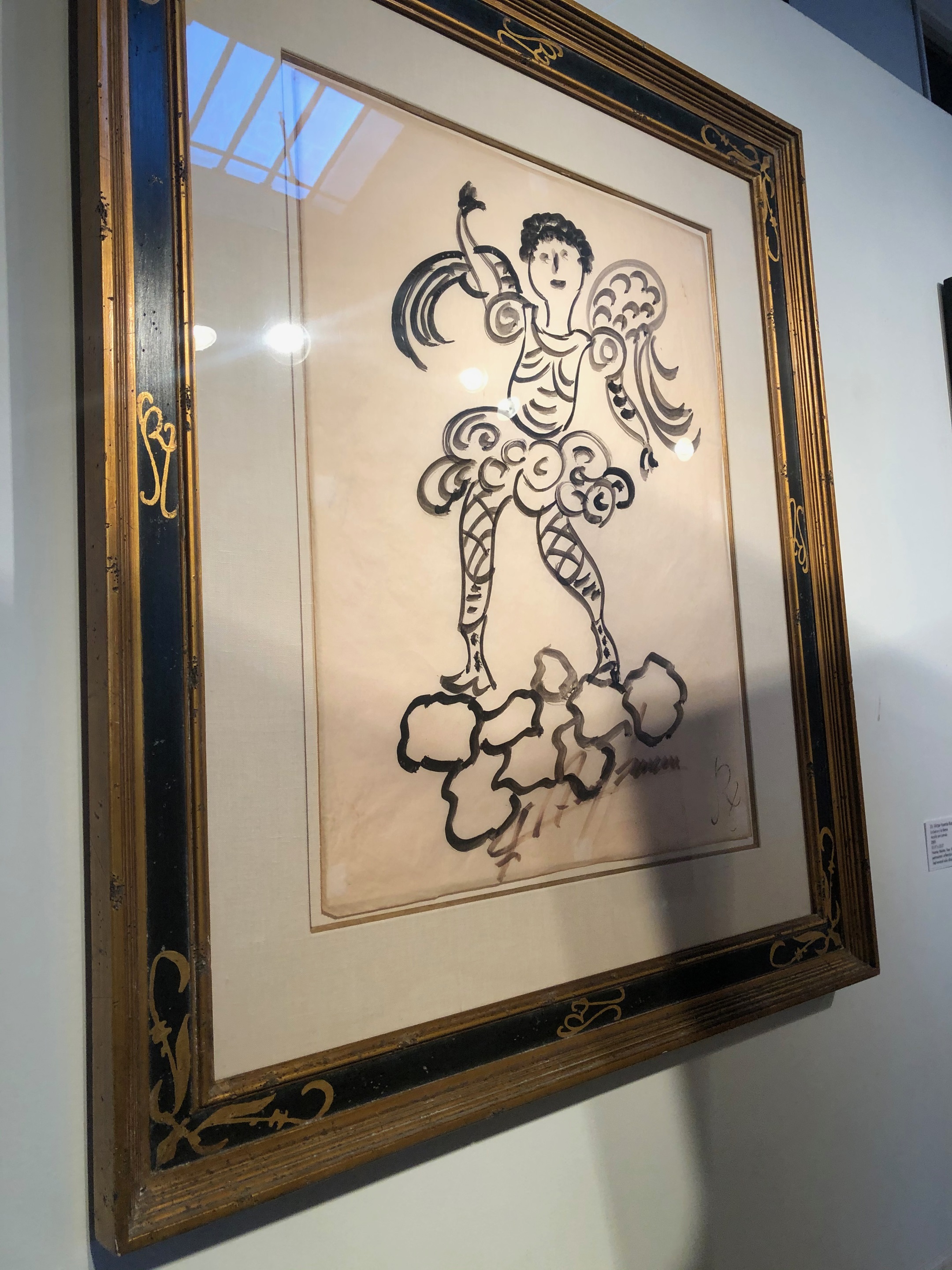 A framed drawing of an angel on a cloud.