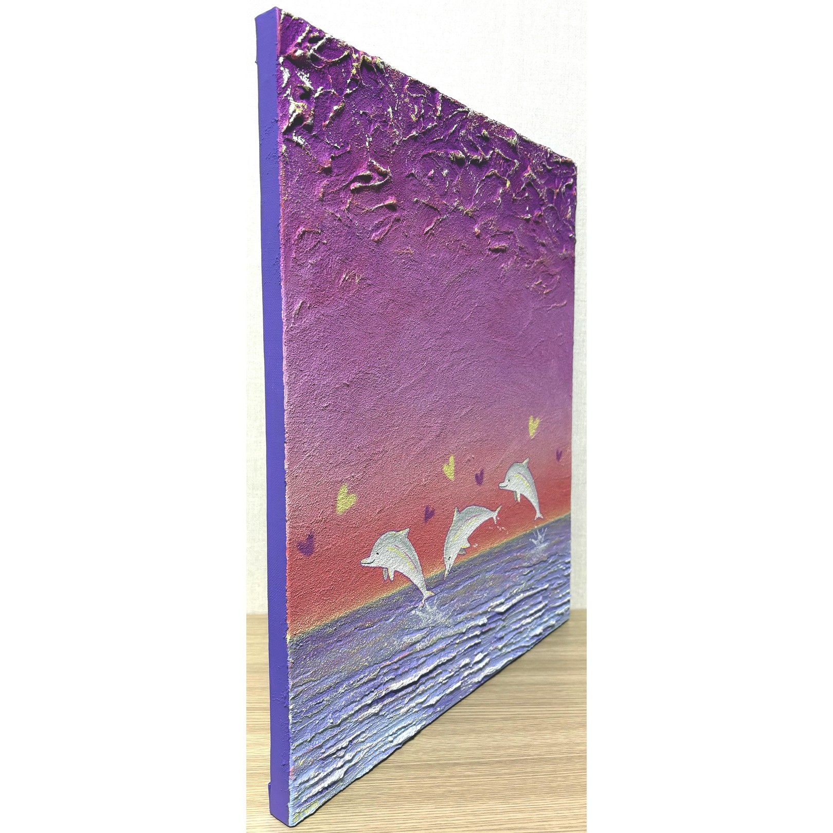 A painting of three dolphins jumping out of the water.