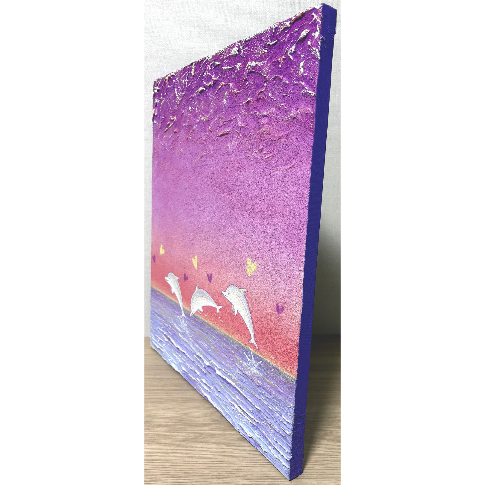 A painting of three dolphins jumping out of the water.
