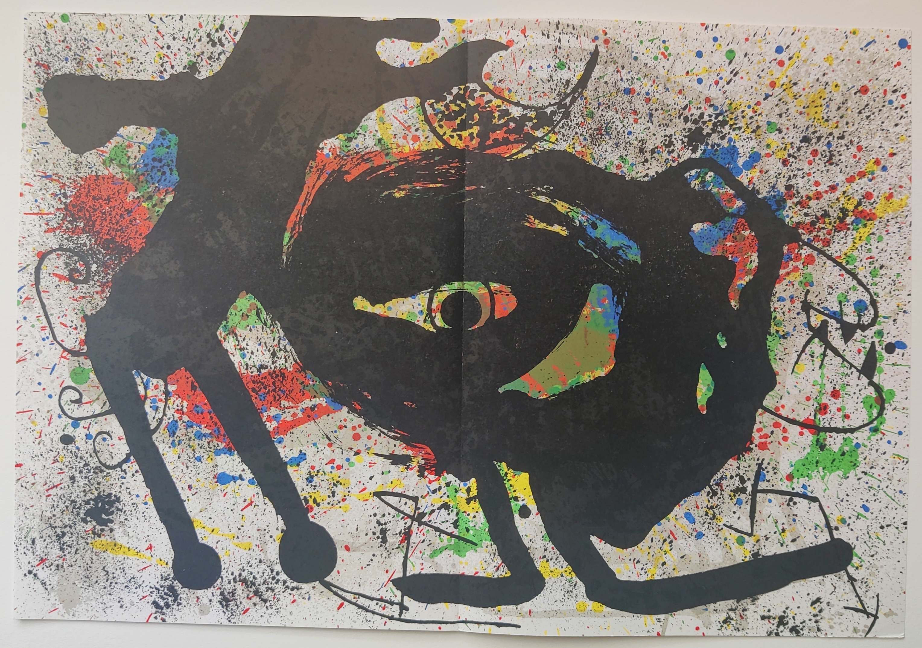 A painting of a black cat with colorful paint splatters on it.
