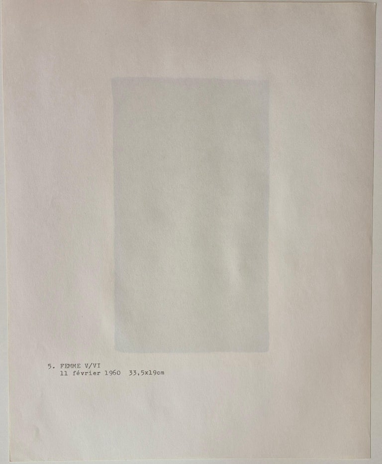 A black cat sitting on top of a red and black tile.