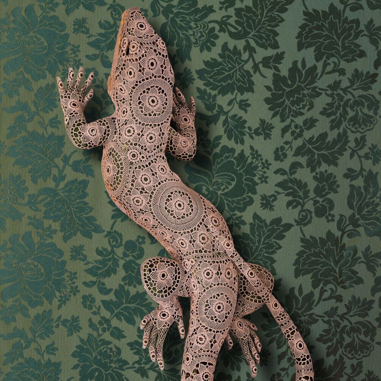 A lizard made out of paper on a green background.