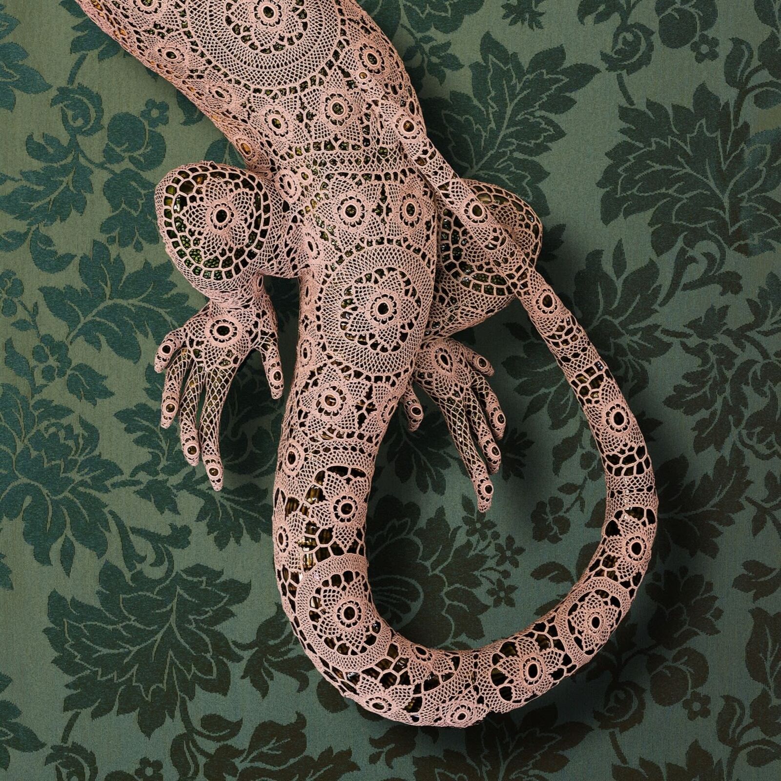 A lizard made out of paper on a green background.