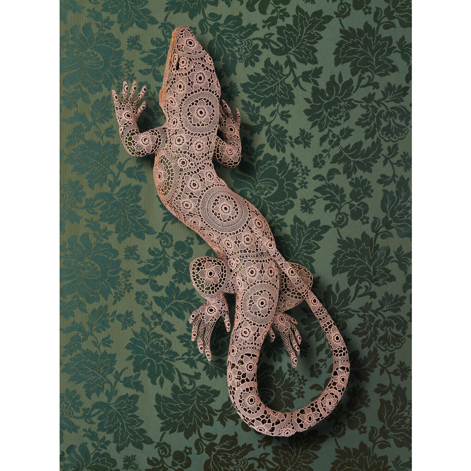 A lizard made out of paper on a green background.