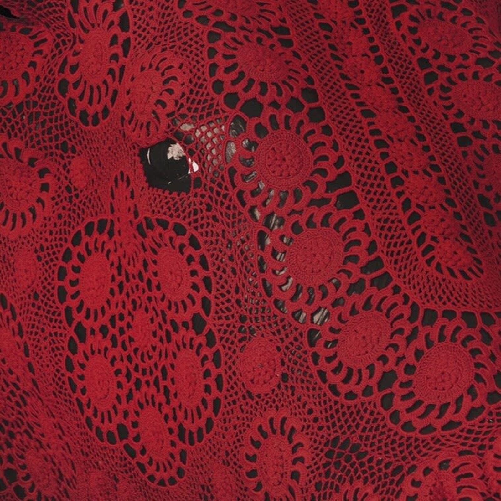 A striking red bull skull covered in intricate lace against a dark floral background.