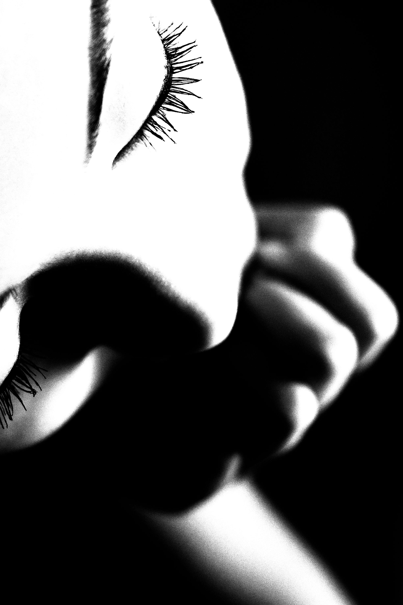 A black and white photo of a woman's face with long eyelashes.