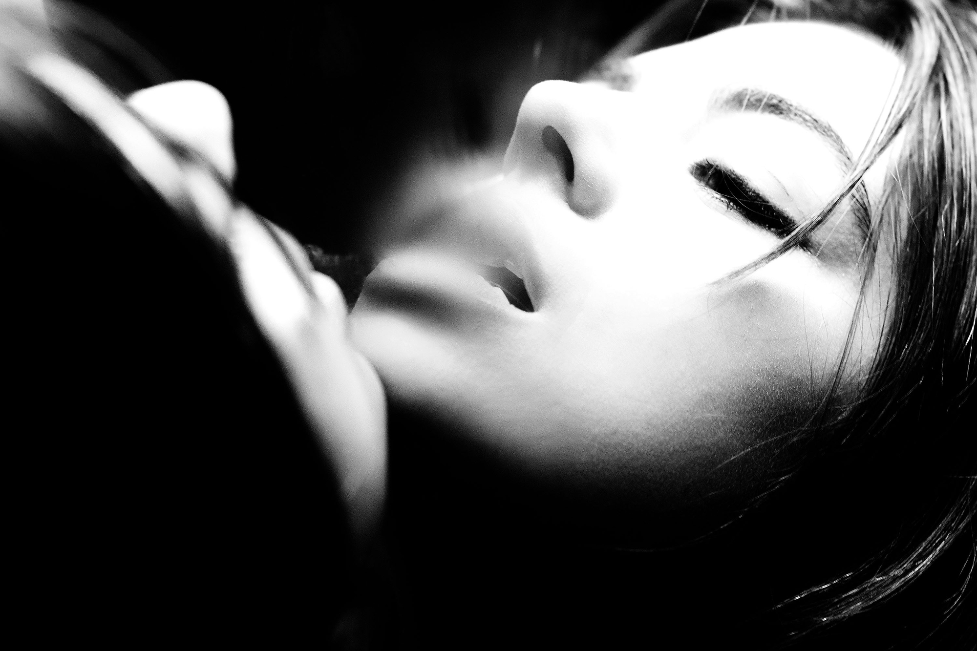 A black and white photo of a woman with her eyes closed.
