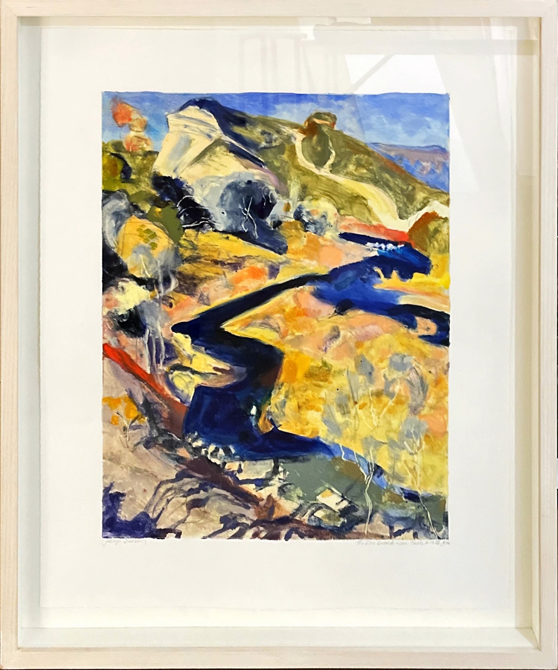 A painting of a mountain scene in a white frame.