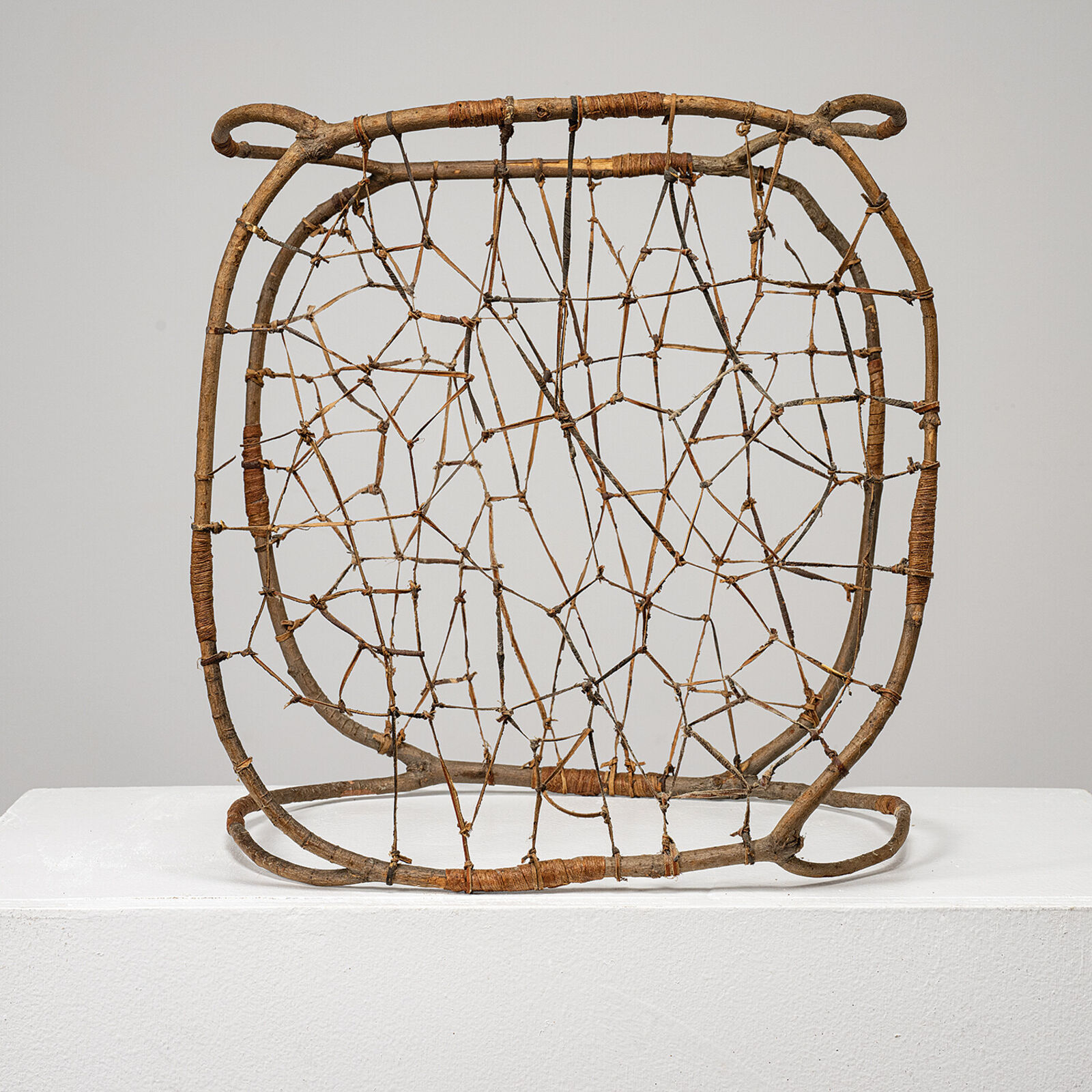 A rustic woven chair made from natural branches and twigs.