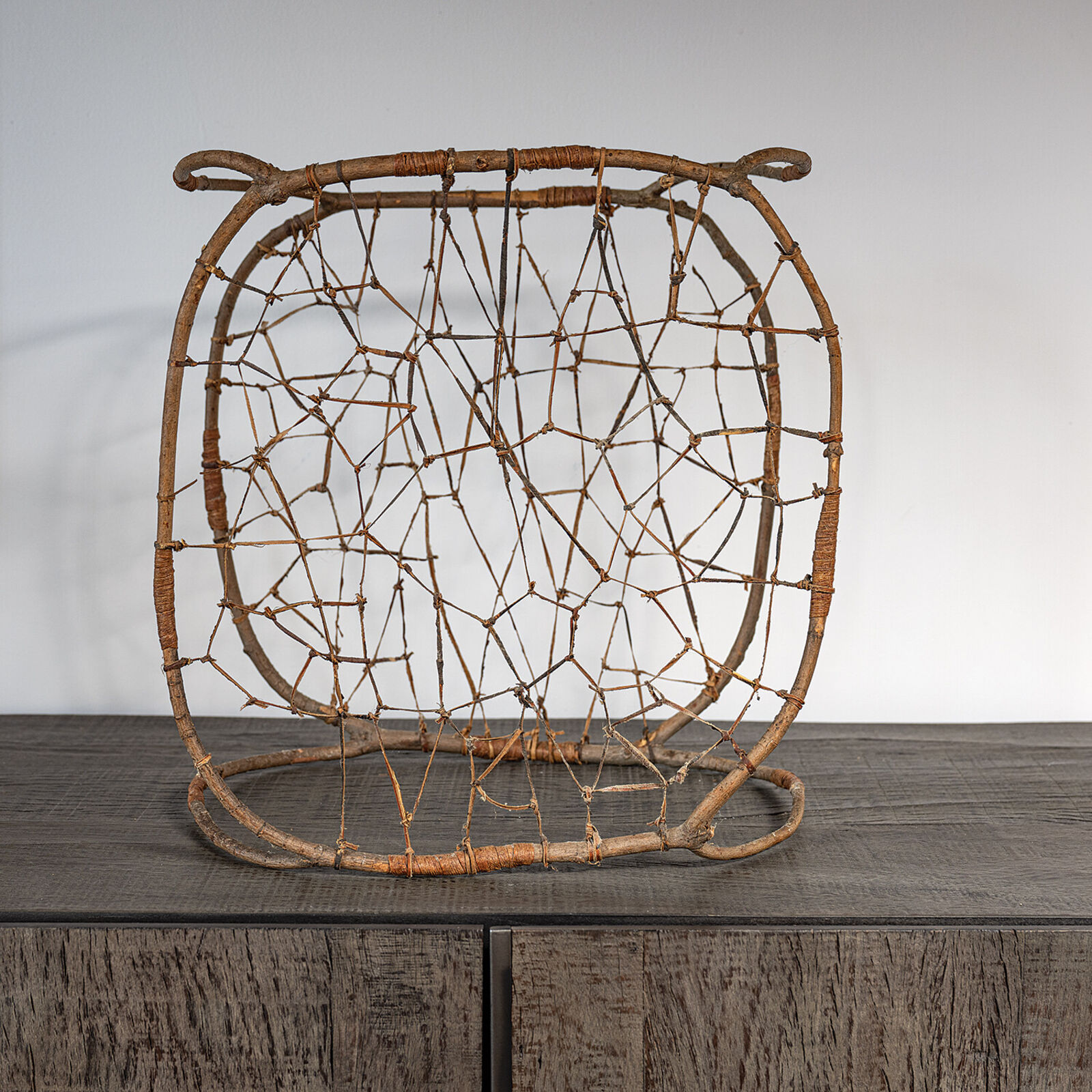 A rustic woven chair made from natural branches and twigs.