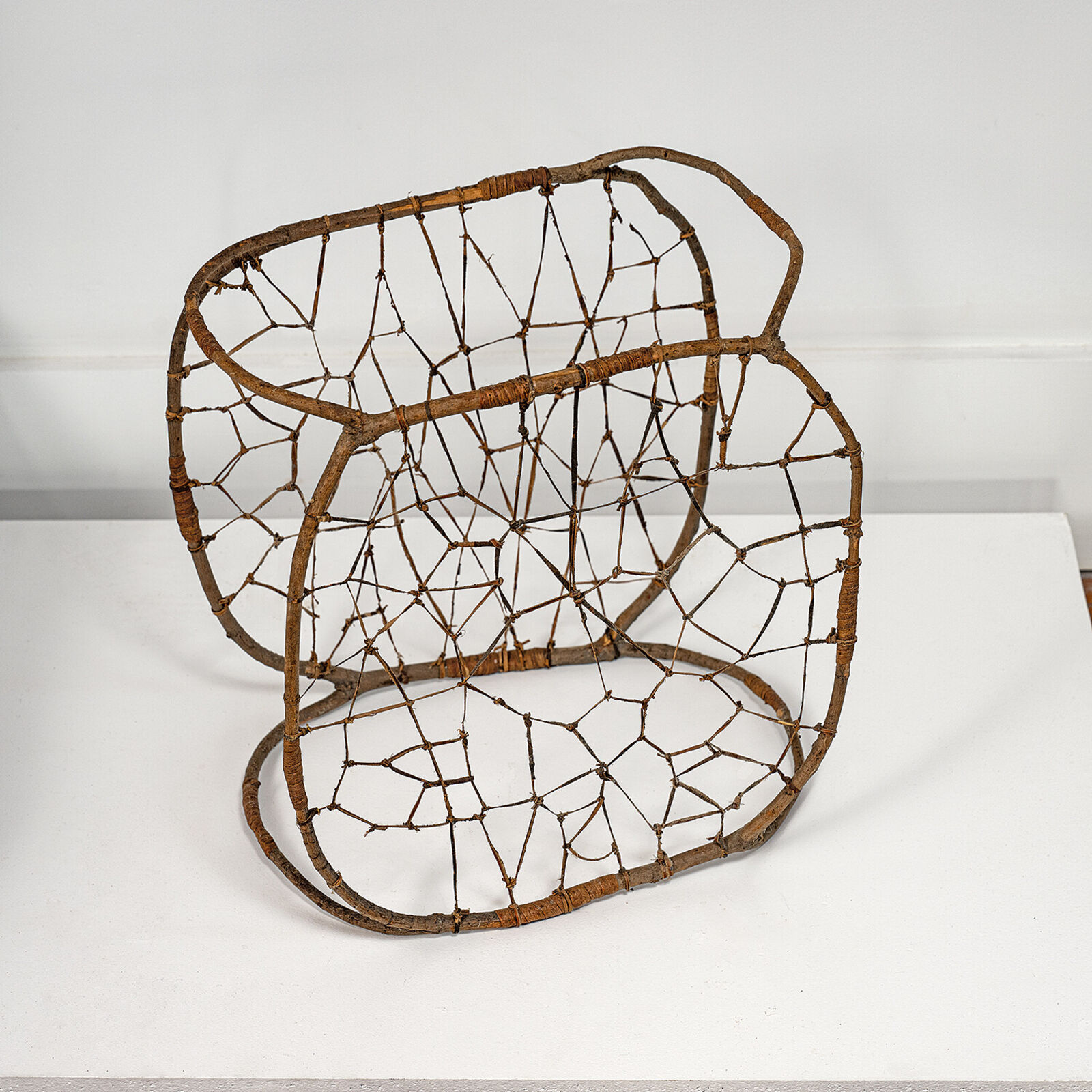 A rustic woven chair made from natural branches and twigs.