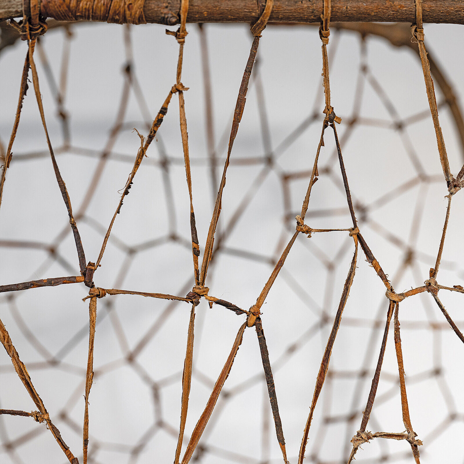 A rustic woven chair made from natural branches and twigs.