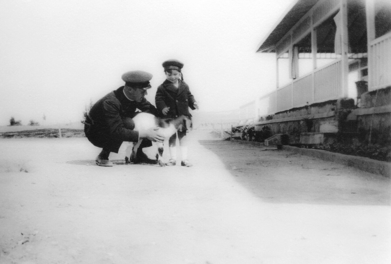 A man kneeling down next to a little boy and a dog.