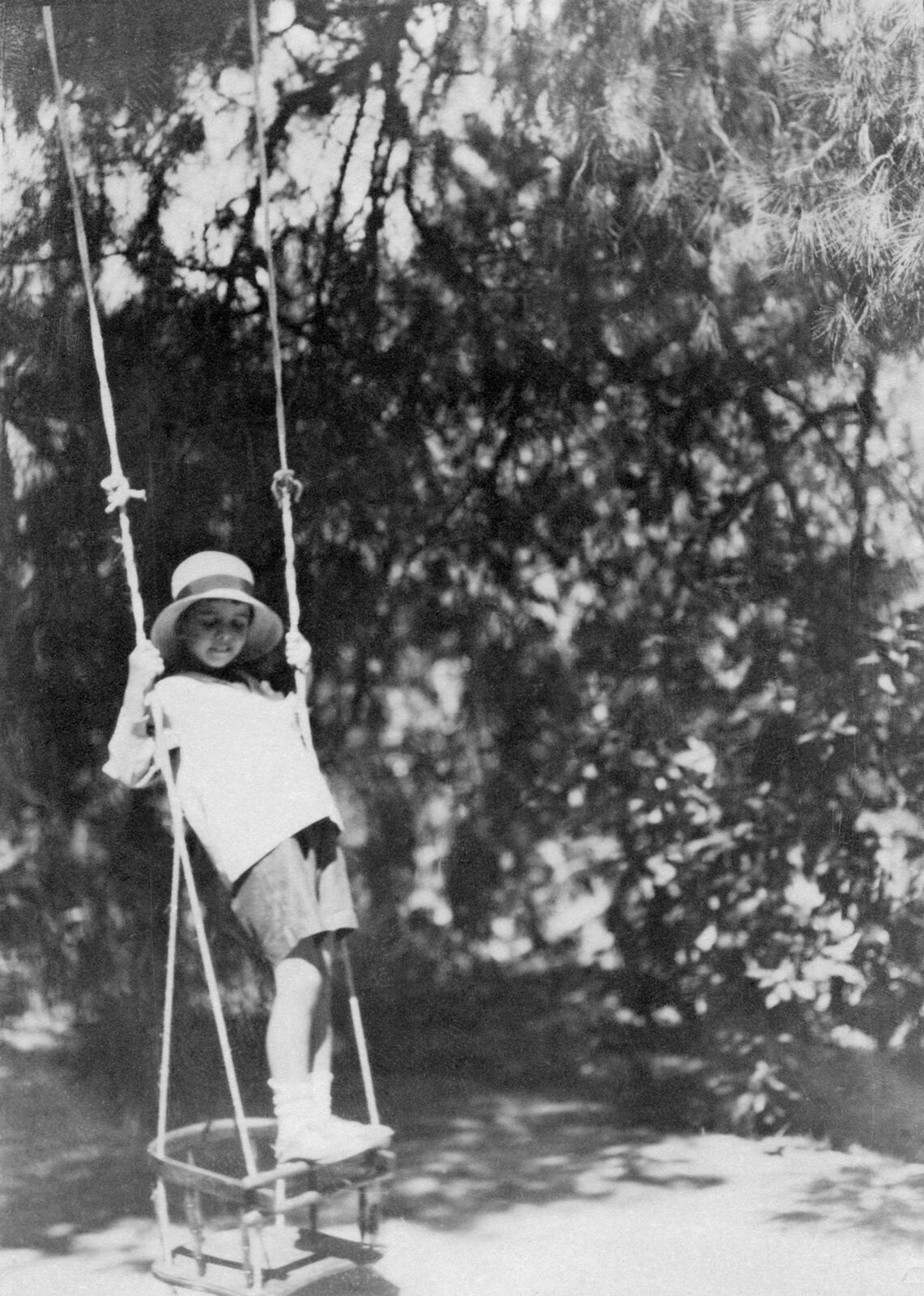 A young girl on a swing in a park.