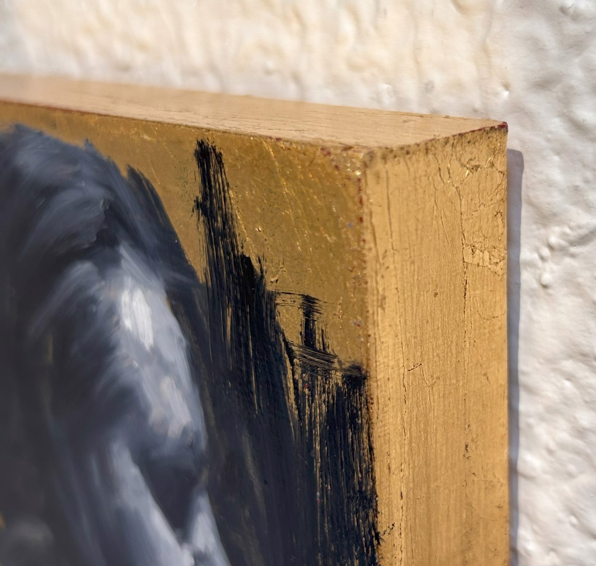 A painting of a man's face on a gold background.