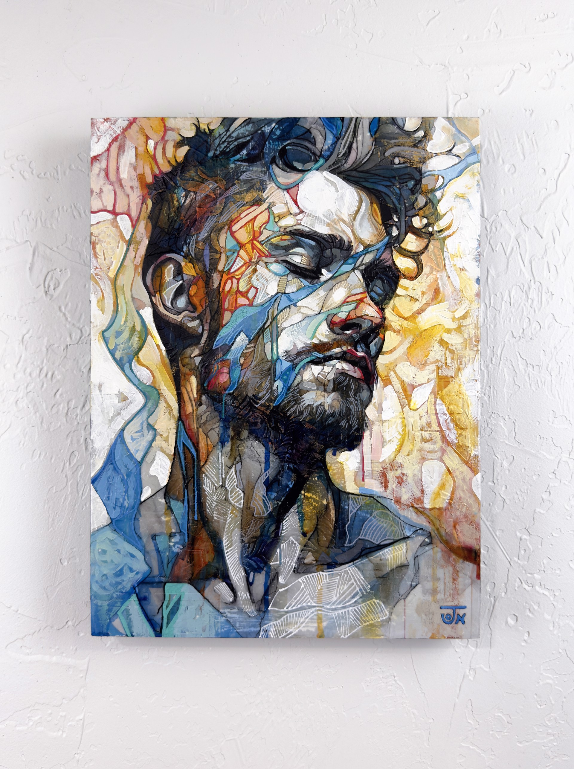 A portrait of a bearded figure with a fragmented, abstract face against a vibrant background.