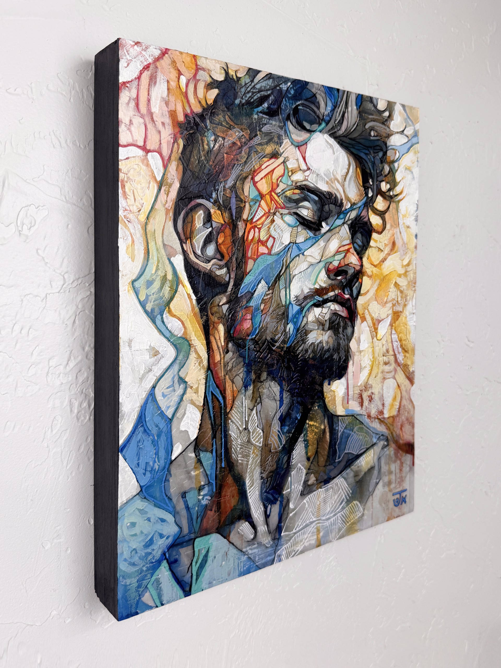 A portrait of a bearded figure with a fragmented, abstract face against a vibrant background.