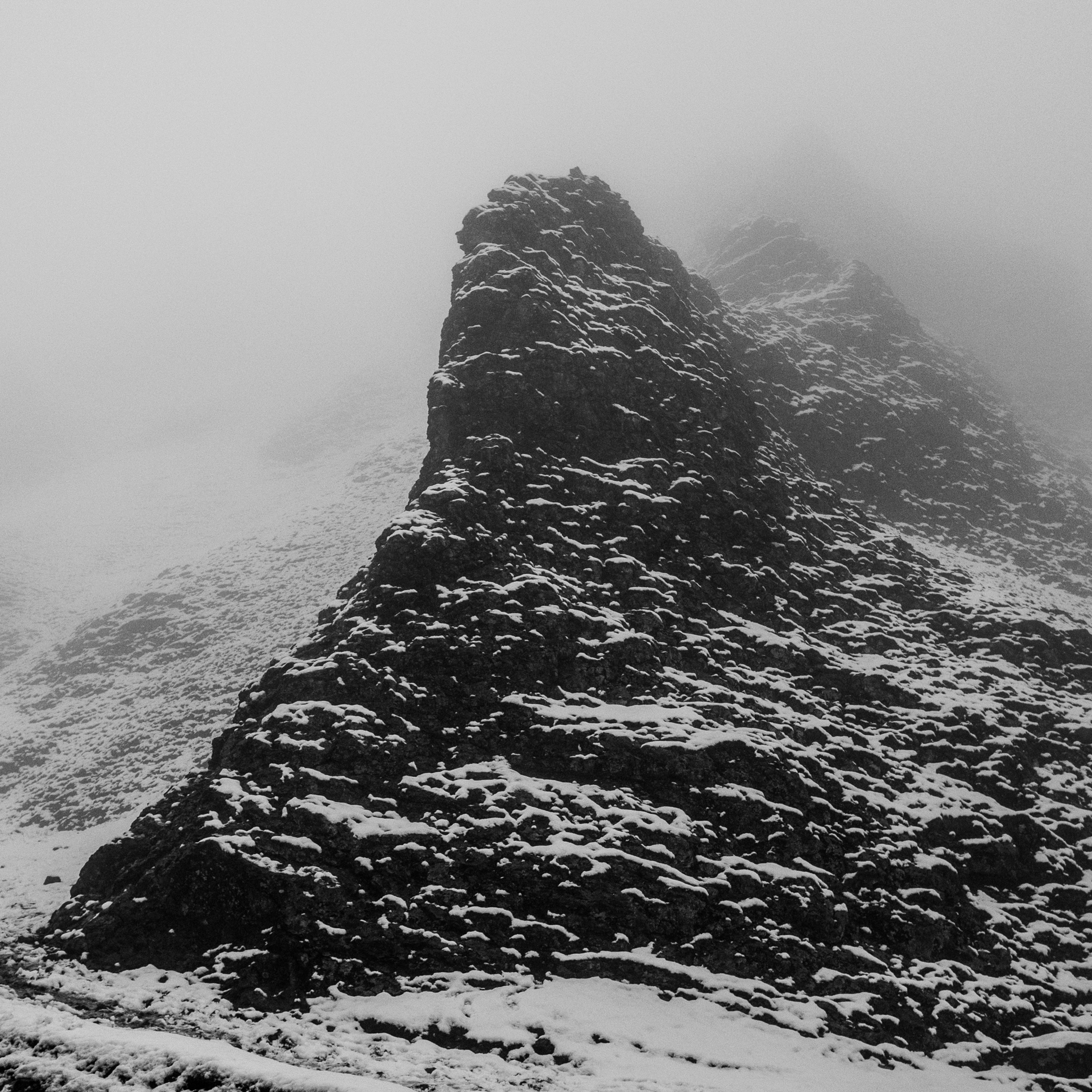 A black and white photo of a snow covered mountain.