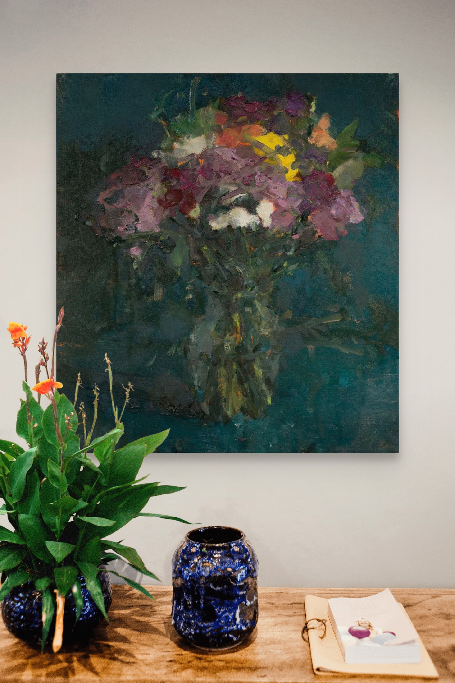 A vibrant bouquet of flowers in a vase against a dark teal background.
